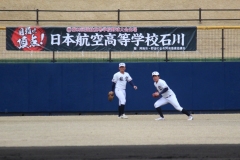 阿南市野球のまち推進課から贈られた横断幕を背にシートノックに取り組む日本航空石川